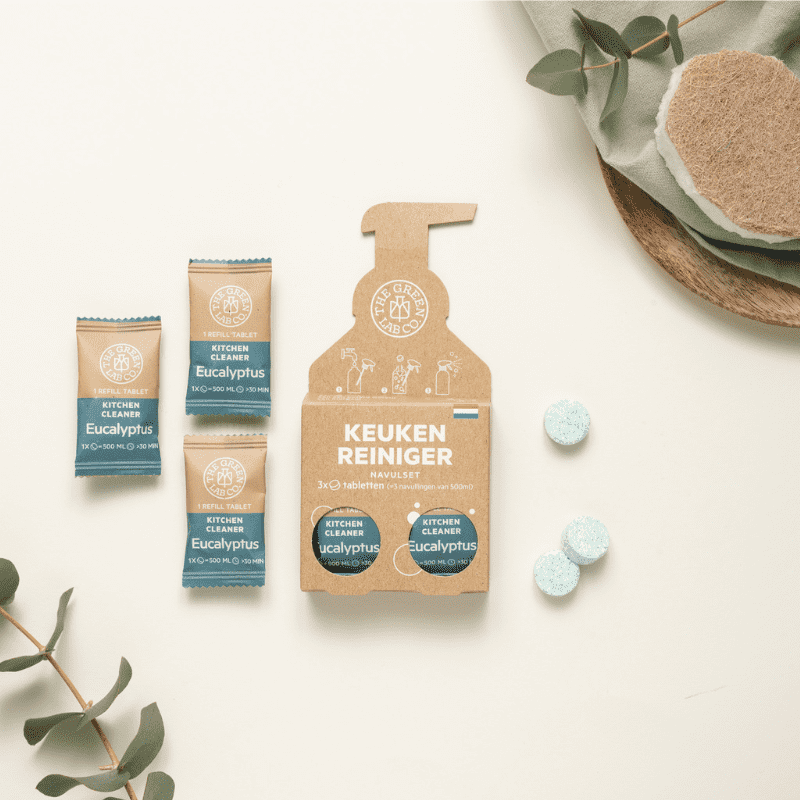 Eco-friendly kitchen cleaner refill tablets with eucalyptus scent – 3 dissolvable tablets in paper packaging, laid out with leaves, sponge, and soft natural tones.